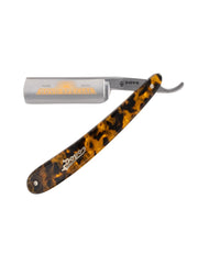 A straight razor with an imitation tortoise shell handle and a gold-plated blade with ornate detailing.