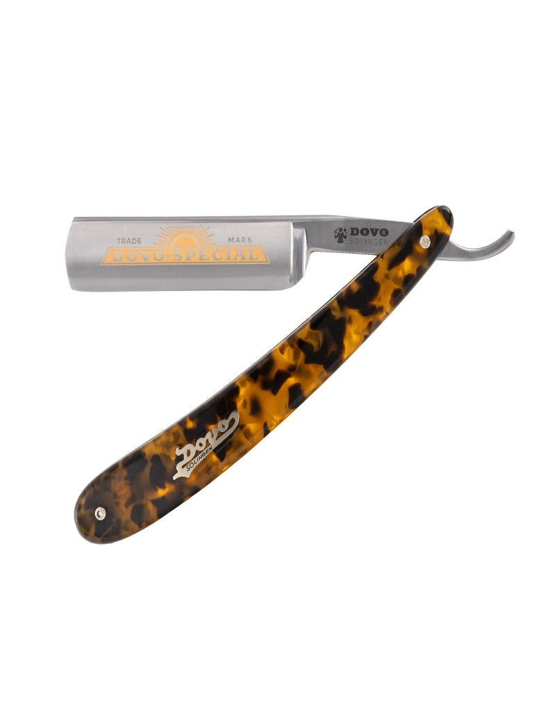 A straight razor with an imitation tortoise shell handle and a gold-plated blade with ornate detailing.