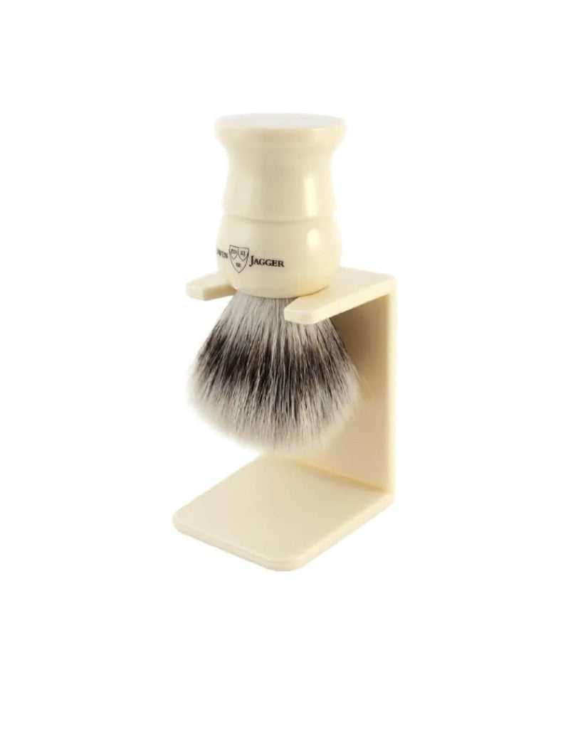 An Edwin Jagger English Shaving Brush with synthetic bristles, imitation ivory handle, and a matching drip stand.