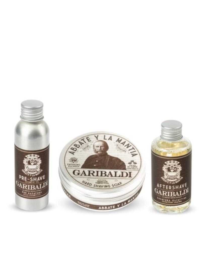 The image shows three products from the Shaving Routine Garibaldi Set which includes a pre-shave oil, shaving soap, and after-shave lotion. The items are presented in a gift box with branding and product information.