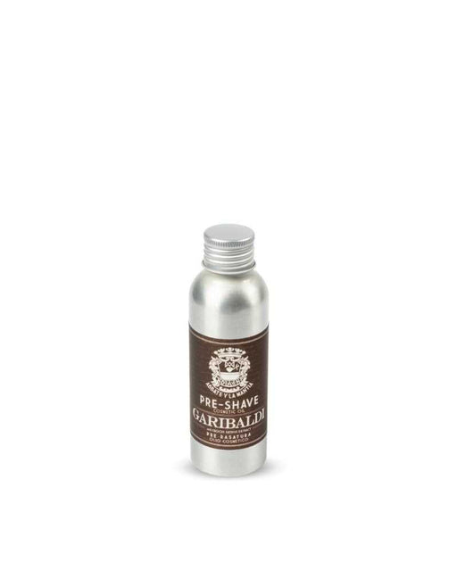 A bottle of 'Abbate y La Mantia - Garibaldi Pre-Shave Oil' with a label that has an image of a bearded man and the product name. The bottle is metallic and has a white cap.