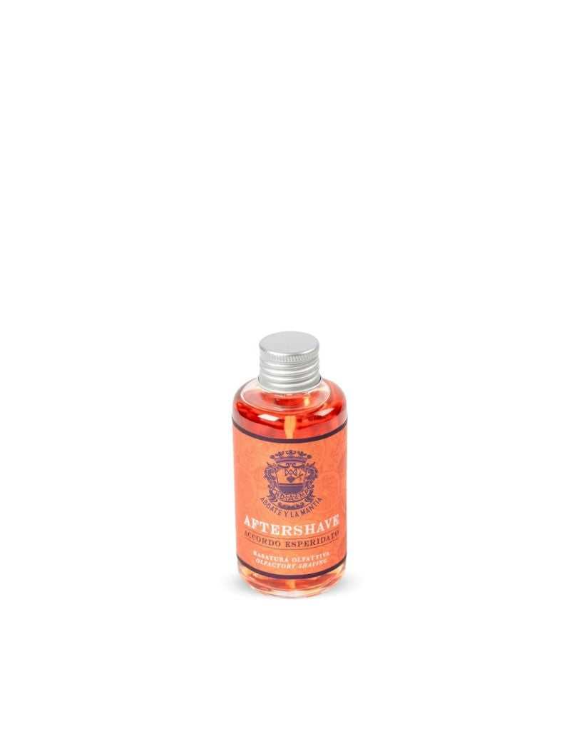 A bottle of Abbate y La Mantia Citrus Accord Aftershave Perfume with orange liquid visible through the transparent glass