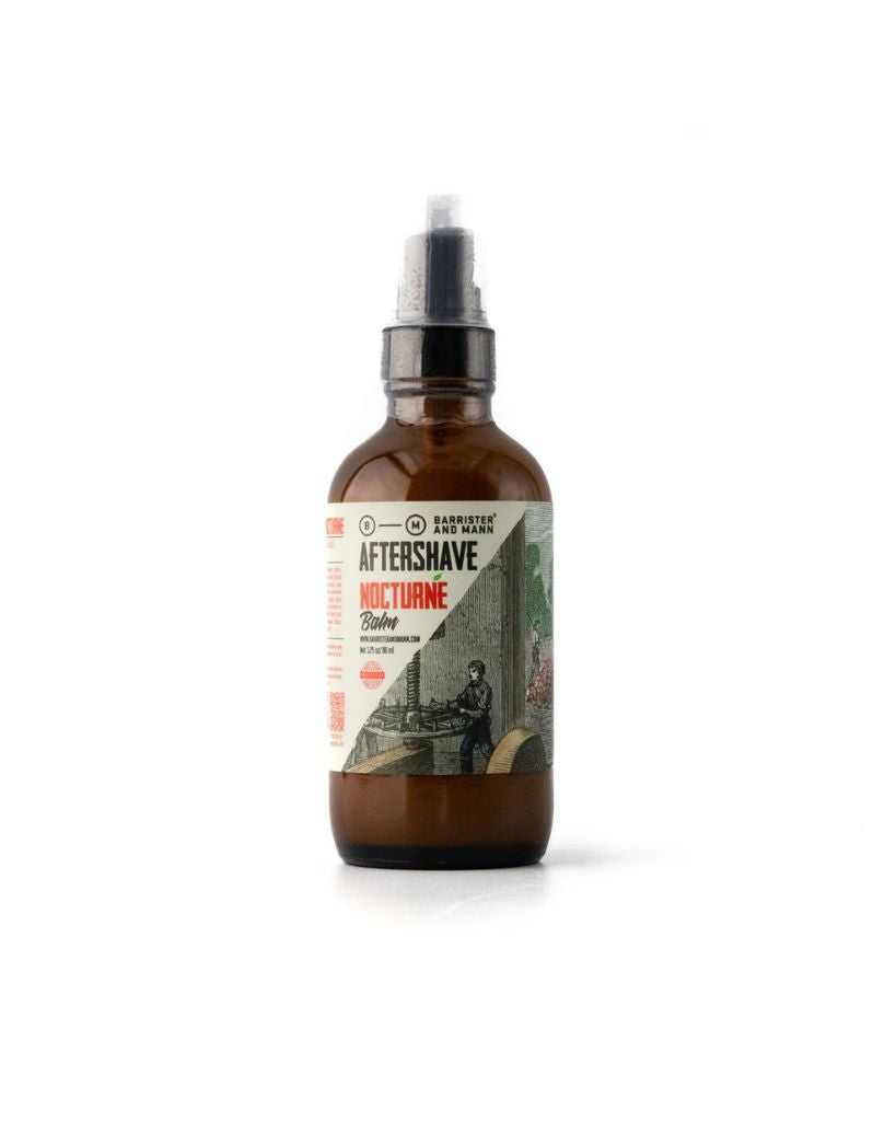 A bottle of Barrister and Mann Nocturne After Shave Balm with a label depicting a man in a suit walking through a autumnal scene with leaves on the ground and trees in the background.