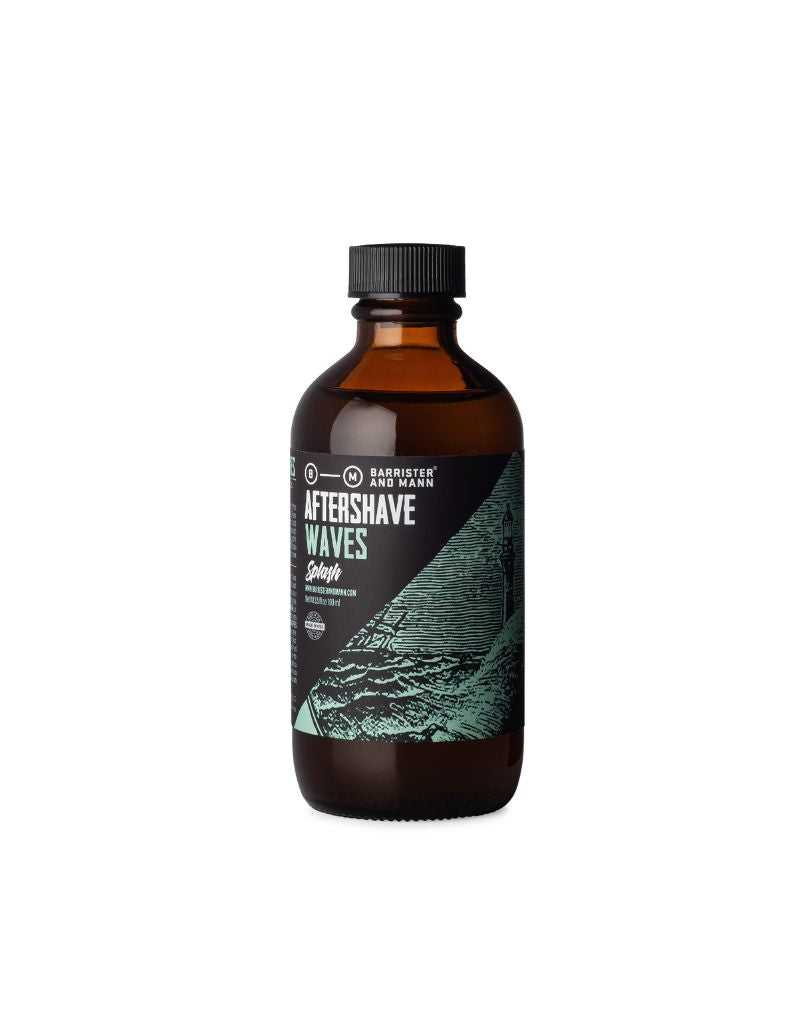 A aftershave splash bottle with a label that reads 'Barrister and Mann AFTERSHAVE WAVES'. The bottle is dark amber with a black cap and a label featuring a blue wave design.