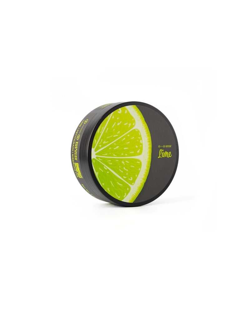 A shaving soap container designed to resemble a lime slice, with green and black colors and the brand name 'Barrister and Mann' displayed.