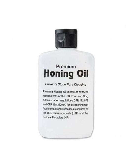 A bottle of Boker Premium Honing Oil with black cap, primarily white label with black text, designed for sharpening Arkansas oil stones.