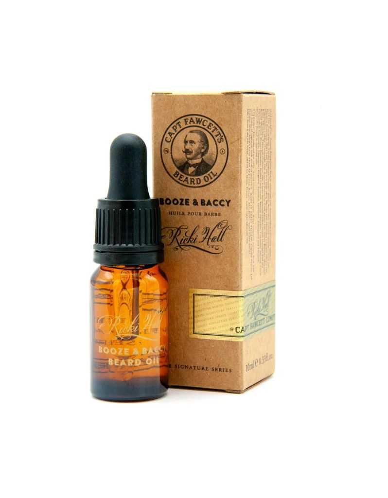 A bottle of Captain Fawcett Booze & Baccy Beard Oil with a dropper, in front of its packaging box.