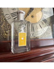 Castle Forbes Keig Eau de Parfum bottle on a wooden mantel in front of an antique clock, elegant citrus fragrance hero shot