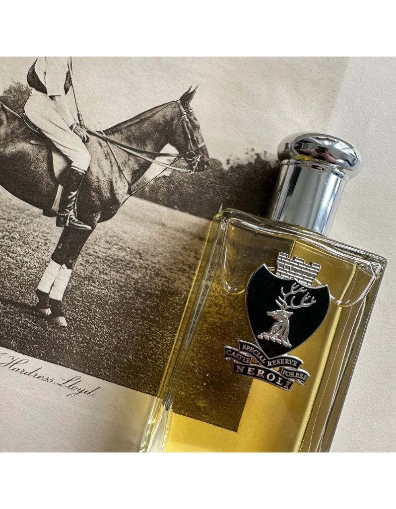 Castle Forbes Special Reserve Neroli Eau de Parfum bottle resting on vintage horse illustration, clear glass with black crest and silver cap