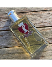 Castle Forbes Special Reserve Sandalwood Eau de Parfum bottle lying on weathered wood, clear glass with burgundy crest and silver cap