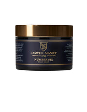 A jar of Caswell Massey Number Six Shave Cream with a black label and gold accents, displaying the product name and branding.