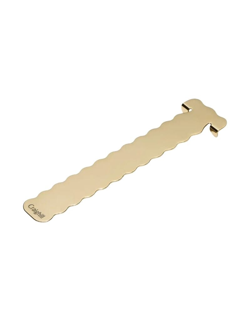 A brass book mark with a wavy profile 