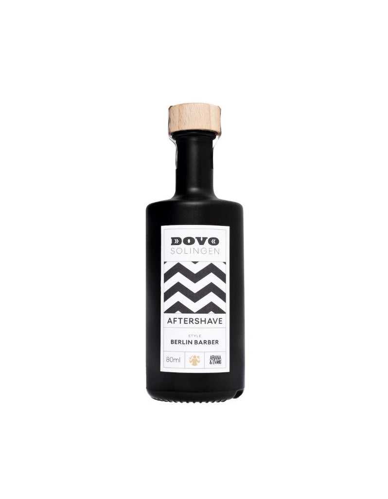 A black bottle with a wooden cap labeled 'Dovo Aftershave Berlin Barber', set against a white background.