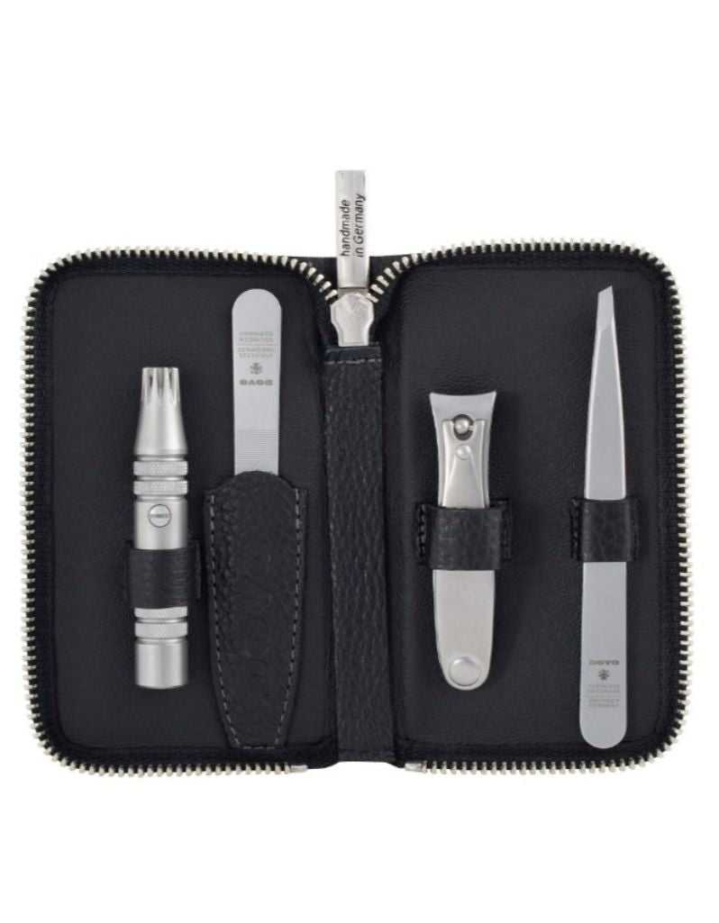 Manicure set with various tools in a black case on a white background