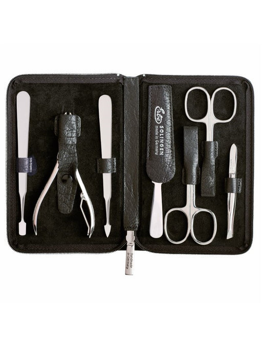 A 7-piece manicure set with tools including scissors, tweezers, a nail file, cleaner, cuticle pusher, and clippers, neatly arranged inside a black leather case with a water buffalo texture.