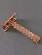 Back view of the Fatip il Grande Gentle copper razor showing the baseplate and fluted handle on a gray background