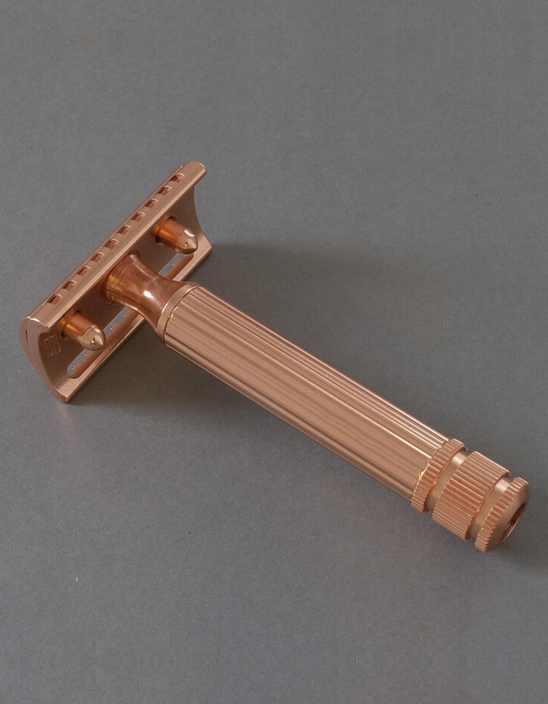 Back view of the Fatip il Grande Gentle copper razor showing the baseplate and fluted handle on a gray background