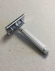 Back view of the Fatip il Piccolo chrome open comb razor showing the baseplate and fluted handle on a gray surface