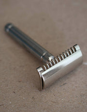 Fatip il Piccolo open comb safety razor in nickel with a fluted handle, resting on a brown kraft surface