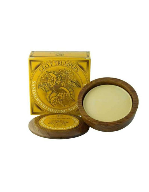 A wooden bowl containing Geo. F. Trumper sandalwood hard shaving soap, with the product's packaging box in the background.