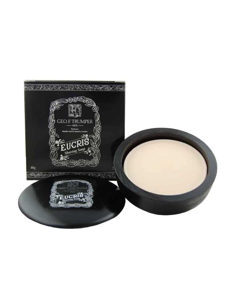 A wooden bowl containing Geo. F. Trumper Eucris Hard Shaving Soap, with the product's packaging box in the background.