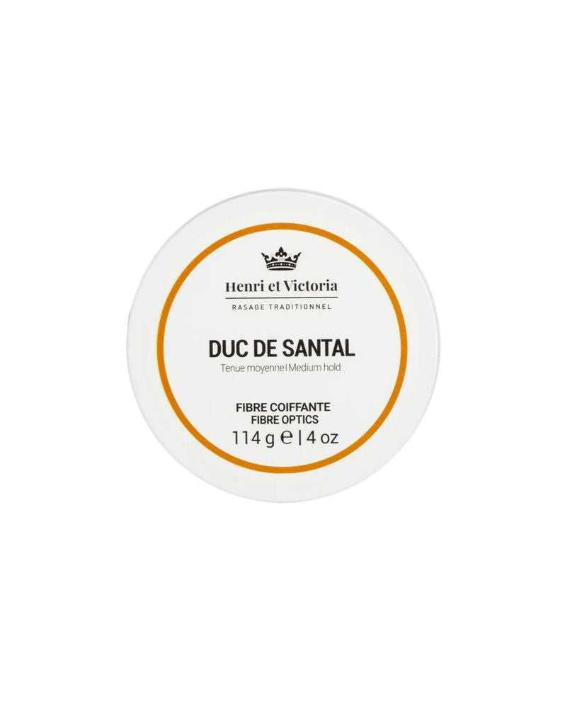 A round container of Henri Et Victoria hair styling product, labeled 'Duc de Santal Fibre Optics' with net weight indicated.