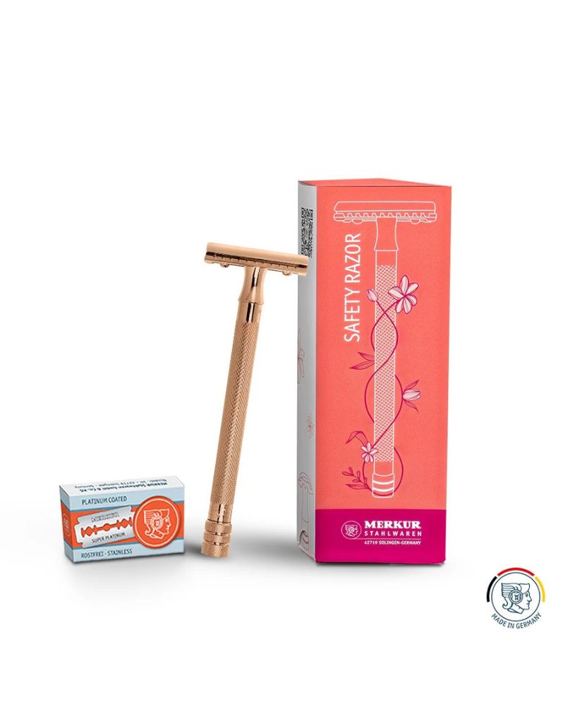 Merkur safety razor with an extra long handle in rose gold color, displayed alongside its packaging and a pack of razor blades.
