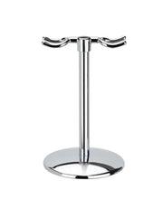 A bright chrome finish razor stand with a round base and two dedicated hooks for holding a razor and brush.