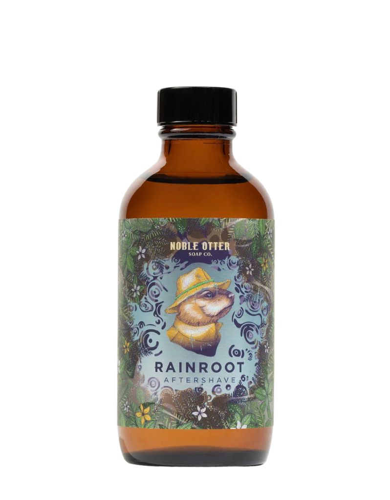 Noble Otter Rainroot aftershave in an amber glass bottle with an otter in a yellow rain hat and coat amid ripples and leaves