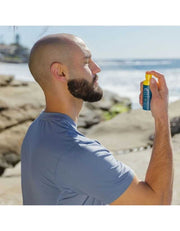 Man using Oars + Alps SPF 35 face mist outdoors