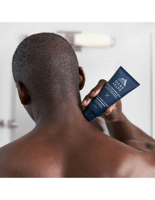 Man applying muscle recovery balm on neck