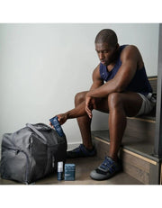 Man using muscle recovery balm on backpack