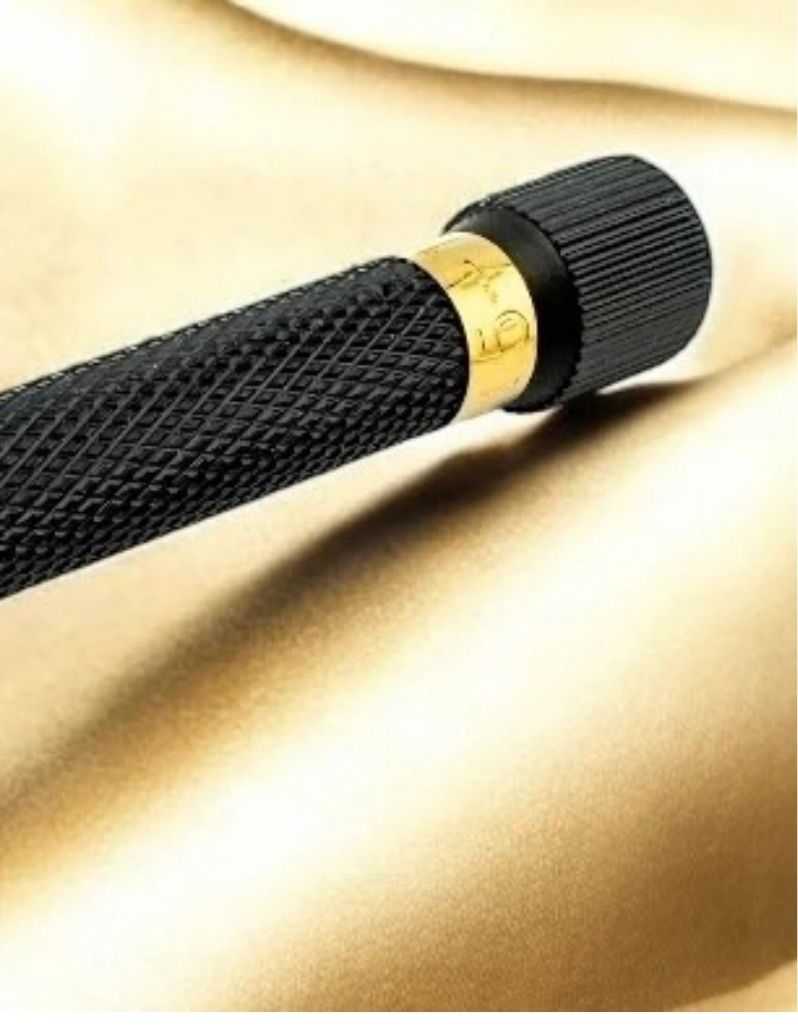 Close-up of textured black safety razor handle with gold ring detail