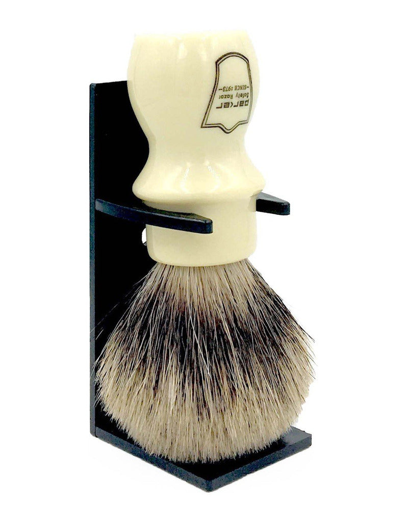 Parker pure badger mug shaving brush with an ivory handle and Parker logo, held upside down in a black drip stand