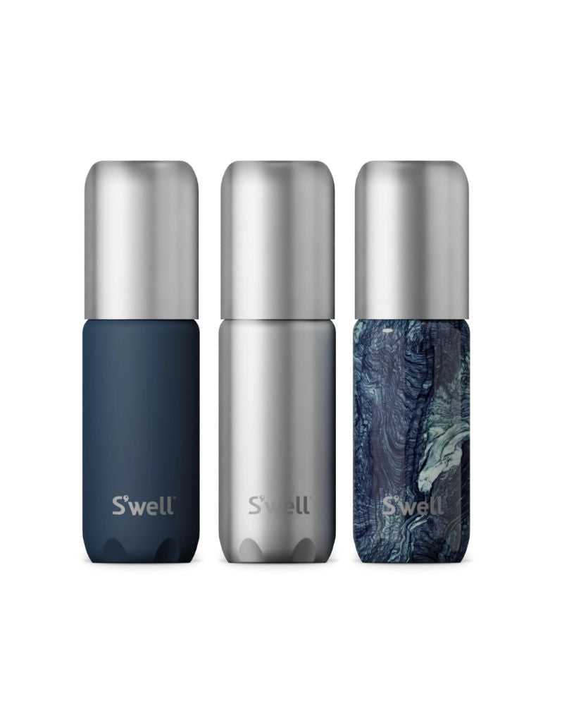 Three S'well travel bottles in blue, silver, and marbled design on a white background