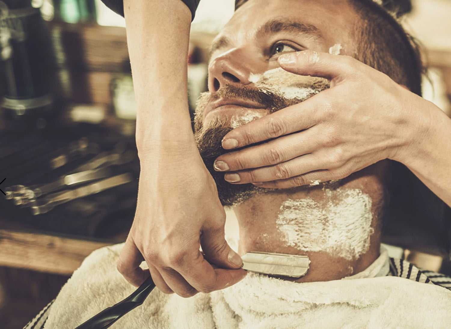 Barber using Feather Artis Club Shavette Straight Razor