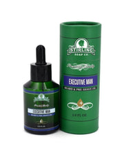 Stirling Soap Co. Executive Man Beard & Pre-Shave Oil shown as a dark green dropper bottle next to its matching green cylindrical packaging tube on a white background.