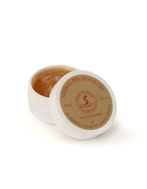 A small open jar of Taylor of Old Bond Street Herbal Pre-Shave Gel, with a beige lid showing product information and branding.