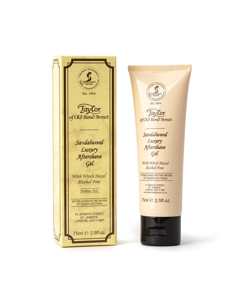 A tube of Taylor of Old Bond Street Sandalwood Luxury Shaving Cream, with packaging displaying the brand and product name, along with the scent notes. The tube is beige with black text and detailing.