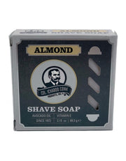 A packaged Colonel Conk Almond Shave Soap puck in a cardboard box with branding and product information displayed.