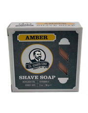 A round amber shave soap puck in a cardboard box with 'AMBER SHAVE SOAP' text and the Colonel Conk logo.