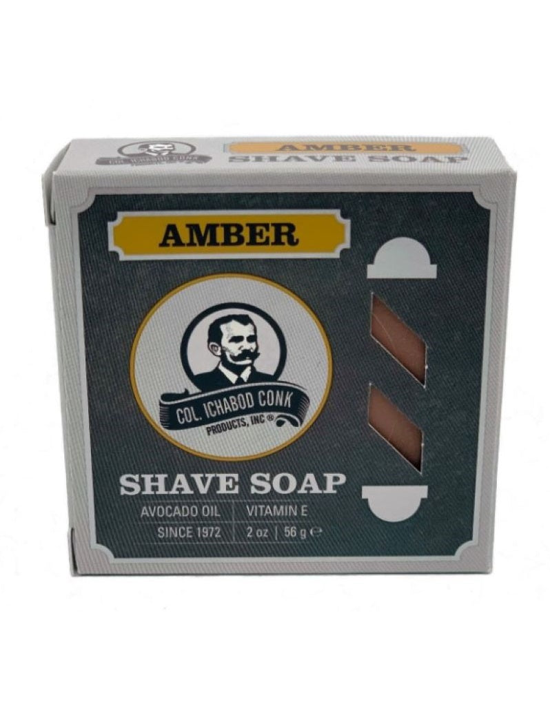 A round amber shave soap puck in a cardboard box with 'AMBER SHAVE SOAP' text and the Colonel Conk logo.