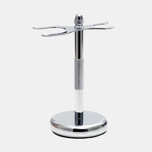 Rockwell chrome-plated brass shave stand with a round base and a central pole, designed to hold a safety razor and a shaving brush.